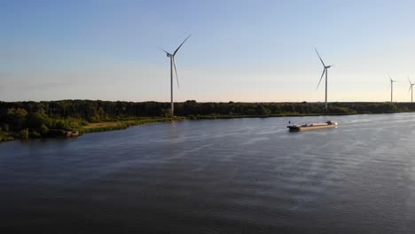 Luftaufnahme-über-Oude-Maas-Mit-Stillen-Windkraftanlagen-Und-Silhouette-Eines-Schiffes,-Das-Sich-In-Der-Ferne-Nähert