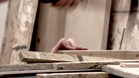 Carpenter-at-work,-using-hand-tools-to-put-spike-shaped-metal-fastener-used-for-joining-wood
