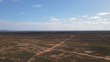 Drone-aerial-of-huge-renewable-energy-wind-farm-in-country-Australia-with-Mountains-in-the-background