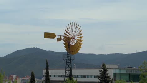 Yellow-wind-wheel-spinning-against-a-bluish-sky-in-Gallecs,-mollet-del-vallés