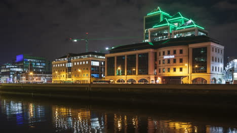 Zeitraffer-Des-Nachts-Beleuchteten-Ulster-Bank-Gebäudes-Mit-Verkehr-Entlang-Des-Flusses-Liffey-In-Der-Stadt-Dublin-In-Irland