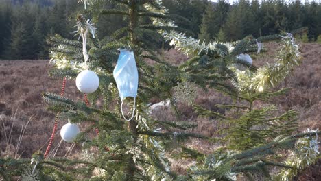 Decorated-Christmas-Tree-With-Face-Mask-Blowing-In-The-Wind-At-Wicklow-Mountains-In-Dublin,-Ireland