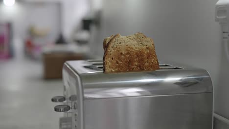 Zwei-Scheiben-Toast-Fallen-Aus-Einem-Toaster-Und-Ein-Mann-Nimmt-Sie