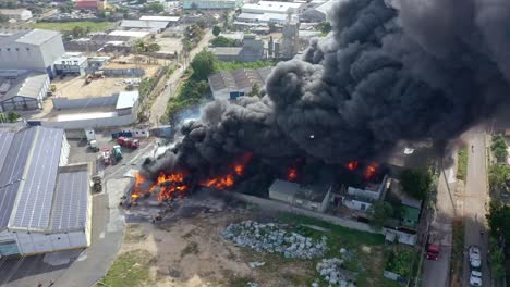 Aerial-drone-shot-over-black-smoke-column-of-burning-warehouse