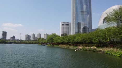 Lotte-Tower-and-people-walking-around-Seokchon-lake-in-park---daytime-in-Spring