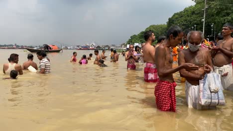 Babu-Ghat,-Kolkata,-India-:-Group-of-Hindu-devotees-doing-"Tarpan"-rituals,-standing-in-Ganges-water