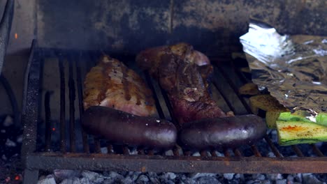 Grilling-beef,-sausage-and-zucchinis-on-a-traditional-parrilla,-Close-up
