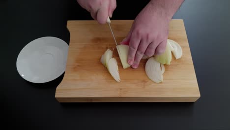 Person-Cutting-White-Onion-On-Wooden-Chopping-Board-With-Saucer-On-The-Side