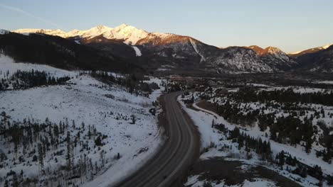 4K-drone-video-of-cars-driving-on-road-in-Rocky-Mountains-in-winter-in-Colorado