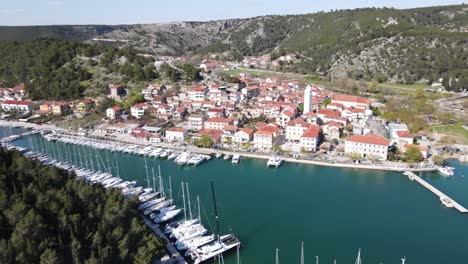 Yacht-marina-Skradin-with-an-aerial-view-over-town,-hills-and-forests-and-green-blue-river-Krka