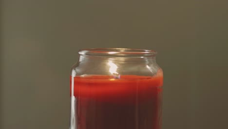 Red-Candle-Burns,-Flame-Flickering-Slowly-Inside-Glassy-Jar