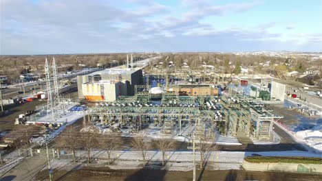 AERIAL---A-power-plant-in-winter-in-Ottawa,-Canada,-wide-shot-forward