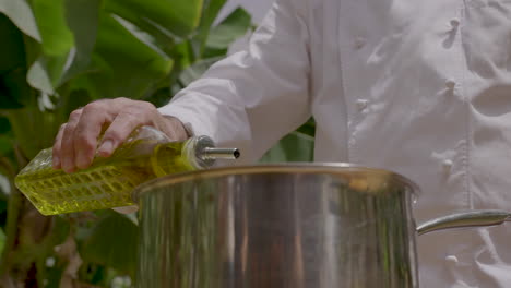 Chef-pouring-extra-virgin-olive-oil-on-a-metal-pan