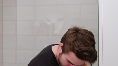 man-trimming-and-shaving-his-own-beard-in-front-of-mirror-in-bathroom