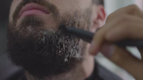 barber-applying-beard-cream-to-man's-beard