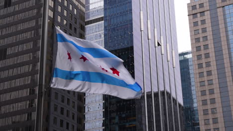 Bandera-De-Chicago-Ondeando-En-El-Viento-Con-Edificios-De-Chicago-En-El-Fondo