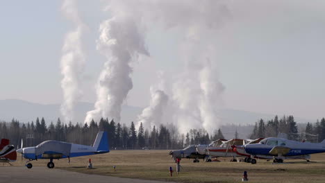View-Of-Aircraft-With-Billowing-Smockestack-At-Background-On-Quesnel-City-Airport,-British-Columbia,-Canada