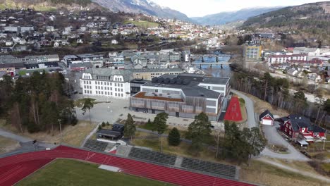 Reverse-aerial-from-Voss-high-school-and-college,-revealing-sports-arena---Norway