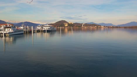 Boote-Vertäut-Am-Lago-Maggiore-Und-Der-Burg-Von-Angera-Im-Hintergrund,-Italien