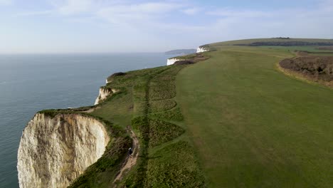 Isolated-hiker-walks-on-top-edge-of-Old-Harry-Rocks-cliff,-Dorset-county-in-England