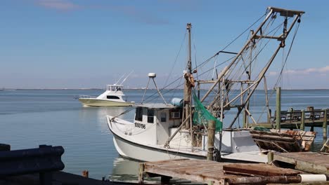 Cabin-Cruiser-navigating-thru-the-Gulf-Interocoastal-Waterway-past-docked-commercial-fishing-boat