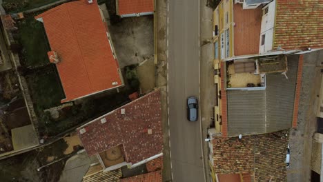 Overhead-shot-of-a-village-road-with-some-cars-passing-by