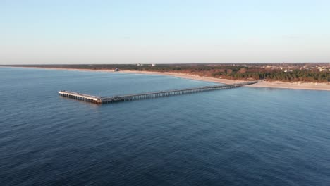 AERIAL:-Palanga-Pier-with-Beautiful-Blue-Baltic-Sea-and-Golden-Hour-Sun-Rays-Falling-on-Sand-Dunes