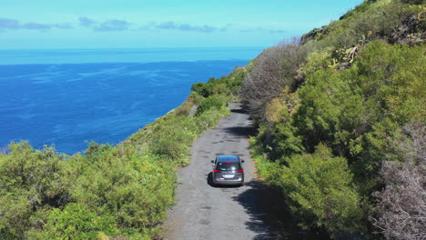 Car-driving-on-a-cliff-road-above-the-ocean,Tenerife,Canary-Islands,Spain