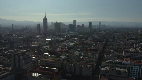 Die-Drohne-Steigt-Auf,-Um-An-Einem-Diesigen-Tag-Die-Skyline-Von-Mexiko-Stadt-Im-Hintergrund-Zu-Enthüllen