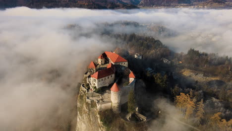 Impresionante-Castillo-De-Bled-Rodeado-De-Niebla-Baja,-Hora-Dorada,-Eslovenia