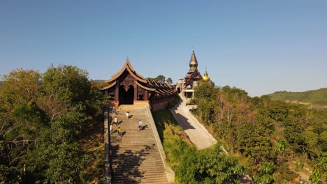 Aerial-footage-of-people-climbing-up-and-down-the-stairs-of-the-famous-Wat-Somdet-Phu-Ruea,-Ming-Mueang,-Loei-in-Thailand