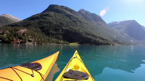 Dos-Kayaks-Flotando-Juntos-En-El-Lago-Lovatnet-Noruega-Durante-Un-Hermoso-Día-De-Verano---Toma-De-Mano-Con-Bengala-De-Una-Pareja-Remando-Juntos---Noruega