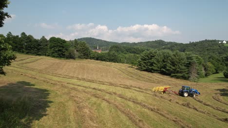 Aerial-Zoom-in-to-Hay-being-harvested-near-Boone-NC,-Boone-North-Carolina-in-Watauga-County