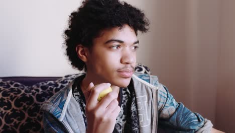A-mix-race-teen-boy-eats-an-apple,-close-up