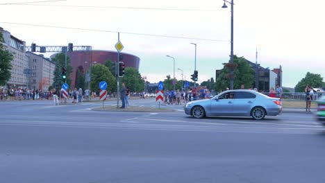 FIA-European-Rally-Trophy-2021-festive-start-and-cars-parade-at-streets-of-Liepaja-,-rally-cars-passing-spectators,-medium-angle-tracking-shot