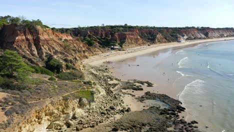 Touristen-Am-Strand-Barranco-Das-Belharucas-Mit-Sandstrand-Und-Ruhigen-Wellen-Im-Sommer-In-Der-Nähe-Von-Albufeira,-Portugal