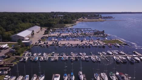 Forward-aerial-of-boats-in-marina-on-sunny-day-in-Whitehall,-Michigan