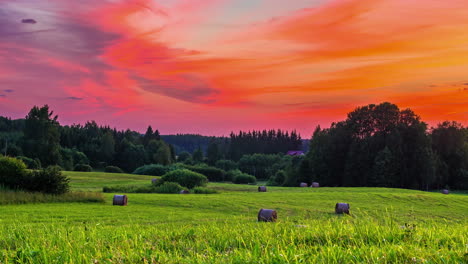 Wunderschöne-Grasfelder-Mit-Strohballen,-Die-Unter-Einem-Farbenfrohen-Himmel-Liegen,-Mit-Zirruswolken,-Die-Sich-Von-Tag-Zu-Nacht-Im-Zeitraffer-Bewegen
