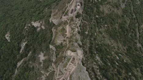 Top-down-view-of-historic-castle-ruin-built-on-high-rocky-French-cliff