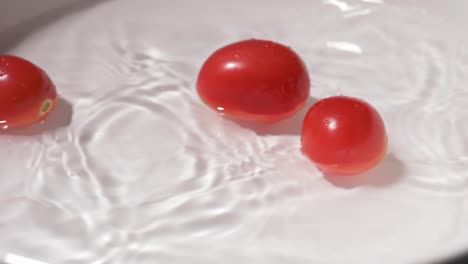 Kleine-Tomaten,-Die-Zur-Reinigung-In-Einen-Behälter-Mit-Wasser-Fallen