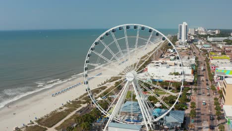 Aerial-of-SkyWheel-amusement-park-attraction-at-oceanfront-vacation-destination,-Myrtle-Beach,-South-Carolina