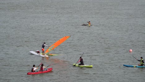 Locals-And-Tourists-At-Han-River-Enjoying-Leisure-Time,-Kayaking-And-Windsurfing-In-Seoul,-South-Korea