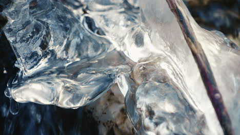 ice-and-icicle-in-a-frozen-river-in-winter-with-flowing-water,-close-up,-slow-motion