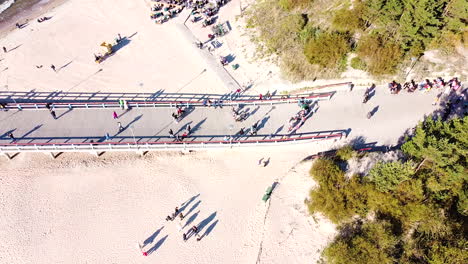 People-walk-on-Palanga-bridge-on-sunny-day,-aerial-static-view