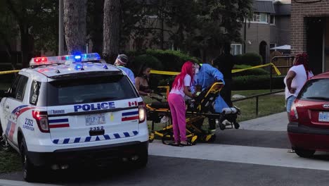 Police-medical-team-treating-a-child-on-stretcher-at-a-incident-spot---Toronto,-Canada