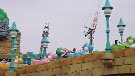 Tourists-ride-on-Yoshie's-Adventure-theme-park-ride-at-Super-Nintendo-Land