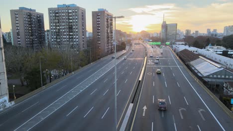 Cinematic-aerial-flyover-La-Plata-Highway-with-traffic-during-golden-sunset-in-background---Old-building-complex-in-La-Boca-Neighborhood-of-Buenos-Aires
