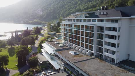 Famous-family-owned-hotel-Alexandra-Loen-Norway---Forward-moving-closeup-aerial-at-sunset-with-solar-flare-and-passing-top-suite