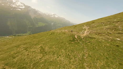 Athlete-Racing-On-The-Narrow-Trail-During-Raid-Evolènard-2021-Race-With-A-View-Of-Val-d'Hérens-Valley-In-Switzerland