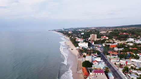 Small-coastal-town-of-Vietnam-with-tiny-sandy-beach-affected-by-sand-loss,-aerial-drone-view